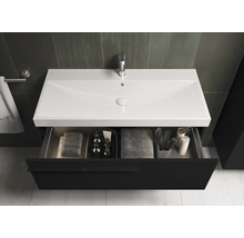 Meuble-lavabo avec tiroir ouvert, lavabo, robinetterie et serviettes dans la salle de bain