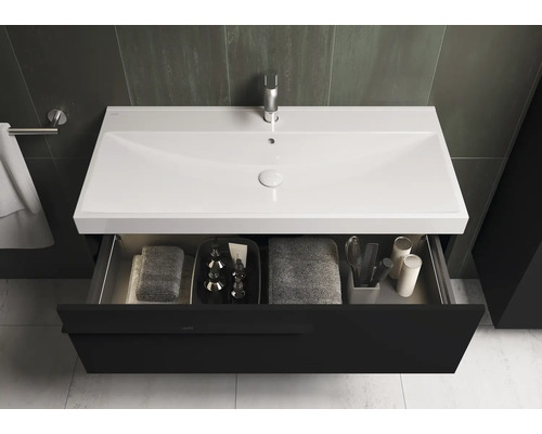 Meuble-lavabo avec tiroir ouvert, lavabo, robinetterie et serviettes dans la salle de bain
