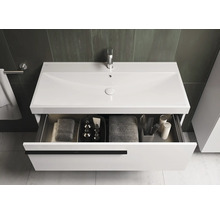 Meuble-lavabo avec tiroir ouvert, serviettes et articles de toilette dans la salle de bain