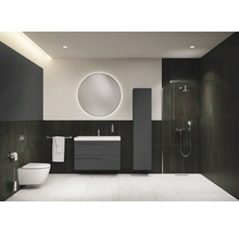 Salle de bains moderne avec toilettes, lavabo, miroir et douche.