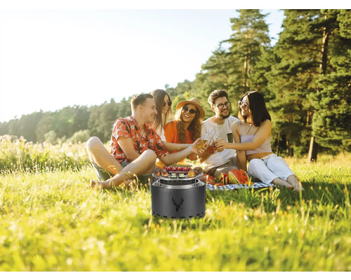 Gruppe von Freunden beim Picknick mit Grill im Freien