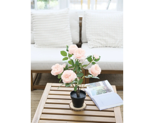 Rose artificielle décorative en pot sur une table en bois