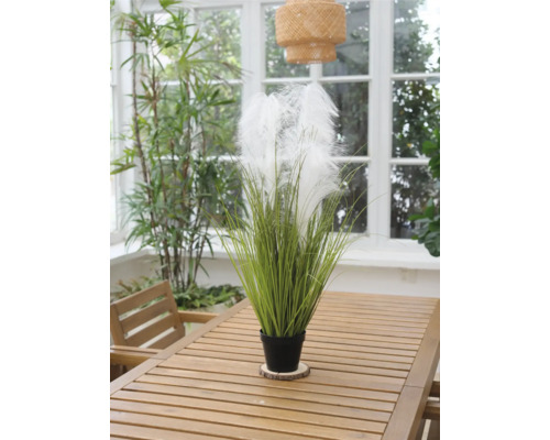 Plante artificielle décorative avec plumes dans un pot sur une table en bois