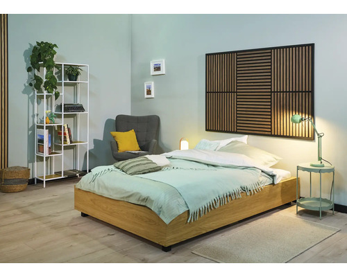 Chambre avec lit, table de chevet, fauteuil, étagère et panneau mural