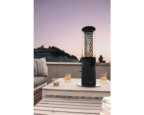 Terrasse avec table, boissons et un chauffage de terrasse noir avec cylindre en verre