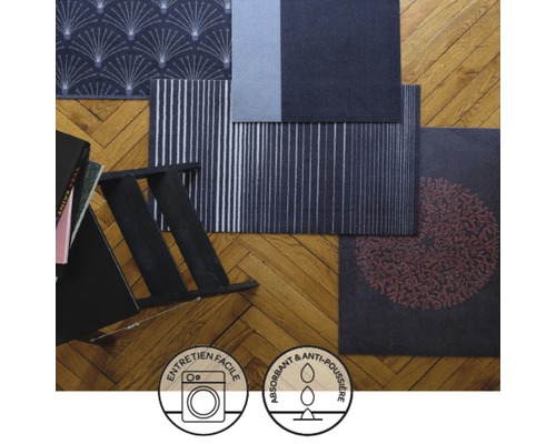 Verschiedene Fußmatten mit Mustern auf einem Holzboden, Symbole für einfache Reinigung und Saugfähigkeit