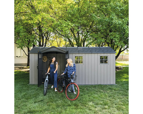Abri de jardin avec deux femmes et des vélos sur la pelouse