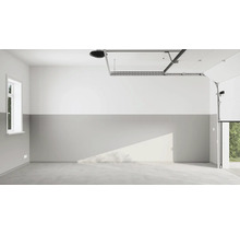 Garage vide avec sol en béton, fenêtre, porte de garage et motorisation de porte de garage