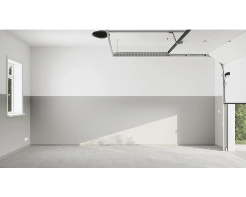 Garage vide avec sol en béton, fenêtre, porte de garage et motorisation de porte de garage