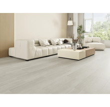 Salon lumineux avec canapé, table basse et grande fenêtre