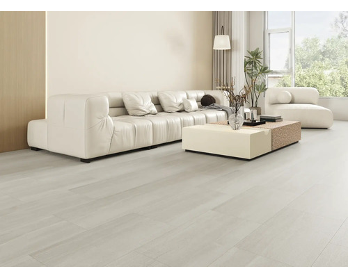 Salon lumineux avec canapé, table basse et grande fenêtre