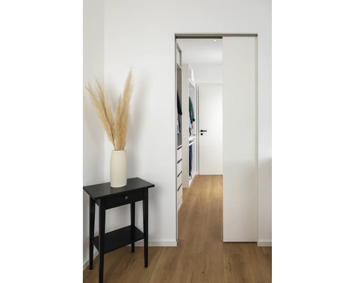 Couloir avec porte coulissante, table d'appoint noire avec décoration et dressing