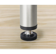 Vue détaillée d'un pied de meuble réglable en métal et plastique sur une surface en bois.