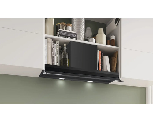 Küchenszene mit Dunstabzugshaube unter einem Regal mit Kochbüchern und Küchenutensilien.