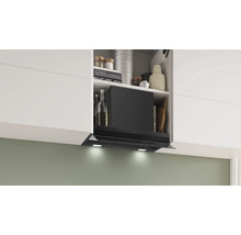 Eine Dunstabzugshaube ist unter einem Küchenschrank montiert und von Kochbüchern und anderen Küchenutensilien umgeben.