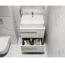 Lavabo de salle de bain avec meuble bas ouvert, robinetterie, miroir et serviettes