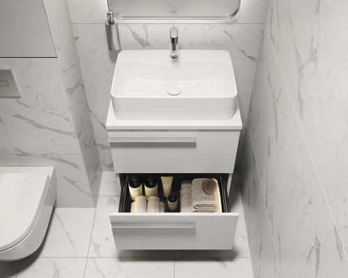 Lavabo de salle de bain avec meuble bas ouvert, robinetterie, miroir et serviettes