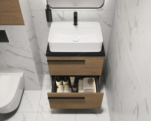 Meuble-lavabo de salle de bains avec tiroirs, vasque à poser et robinet devant un mur carrelé