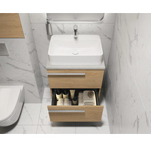 Meuble-lavabo avec tiroir ouvert, robinet et miroir dans une salle de bain lumineuse