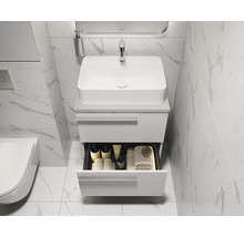 Salle de bains avec meuble-lavabo blanc, vasque à poser et tiroir ouvert pour ranger les accessoires de salle de bains