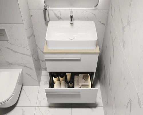 Meuble-lavabo avec tiroir ouvert contenant des accessoires de bain tels que des serviettes et des produits de soins
