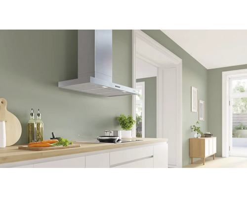 Moderne Küche mit Dunstabzugshaube aus Metall über einem Kochfeld.