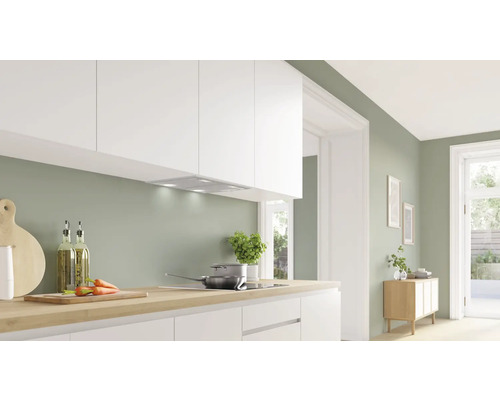 Helle Küche mit Dunstabzugshaube, Kochfeld und Küchenutensilien auf der Arbeitsfläche.