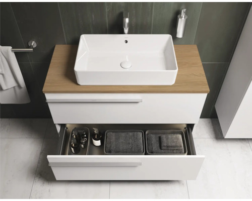 Salle de bain moderne avec meuble-lavabo blanc, plateau en bois et tiroir ouvert pour ranger les accessoires de salle de bain.