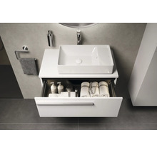 Meuble-lavabo avec tiroir ouvert contenant des serviettes et des produits de soins dans la salle de bain.
