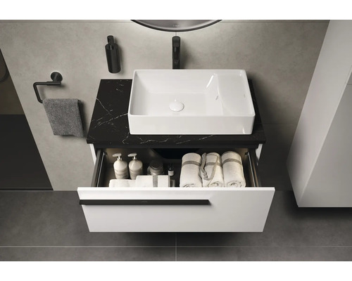 Lavabo de salle de bain avec élément de tiroir ouvert sur un plateau en marbre