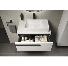 Salle de bains moderne avec meuble-lavabo, vasque à poser rectangulaire et tiroir ouvert avec serviettes et produits de soin.