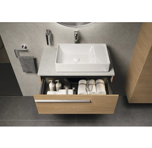 Meuble-lavabo de salle de bain avec tiroir ouvert, lavabo, robinet et serviettes