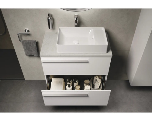 Salle de bains moderne avec lavabo, meuble sous-lavabo avec tiroir ouvert et accessoires de bain.