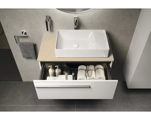 Salle de bains moderne avec meuble-lavabo blanc, tiroir ouvert et serviettes
