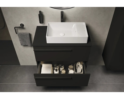 Meuble sous-lavabo avec tiroir ouvert, serviette et distributeur de savon dans la salle de bain