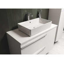 Vasque à poser sur meuble-lavabo blanc avec tiroirs dans la salle de bain.