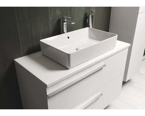Vasque à poser sur meuble-lavabo blanc avec tiroirs dans la salle de bain.