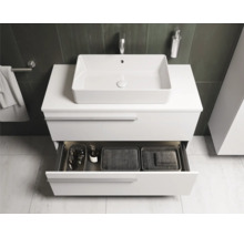 Salle de bains moderne avec meuble sous-vasque blanc, vasque à poser et tiroir ouvert avec accessoires de salle de bains
