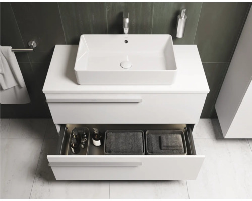 Salle de bains moderne avec meuble sous-vasque blanc, vasque à poser et tiroir ouvert avec accessoires de salle de bains