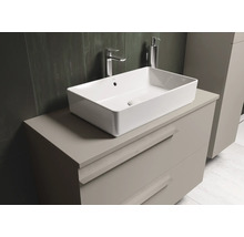 Meuble sous-vasque avec vasque à poser, robinetterie et distributeur de savon dans la salle de bains.