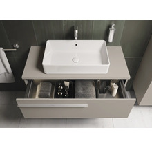 Vue de salle de bain avec lavabo et tiroir ouvert sous le plan de travail, dans lequel sont rangés les serviettes et les accessoires de bain.