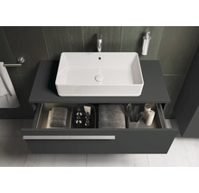 Salle de bains moderne avec lavabo, meuble sous-lavabo et tiroir ouvert pour ranger les serviettes et les produits de soin