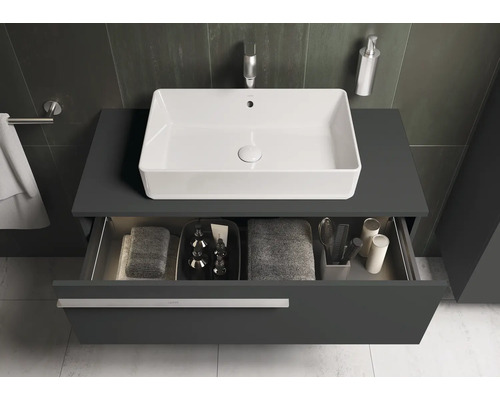 Salle de bains moderne avec lavabo, meuble sous-lavabo et tiroir ouvert pour ranger les serviettes et les produits de soin