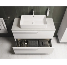 Salle de bains moderne avec lavabo, meuble sous-lavabo avec tiroir ouvert et articles de toilette.