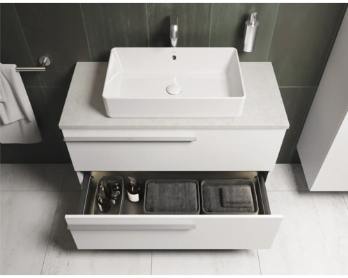 Salle de bains moderne avec lavabo, meuble sous-lavabo avec tiroir ouvert et articles de toilette.