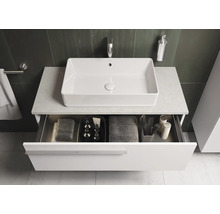 Meuble-lavabo avec tiroir ouvert et vasque à poser rectangulaire dans une salle de bains moderne