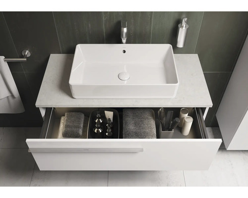 Meuble-lavabo avec tiroir ouvert et vasque à poser rectangulaire dans une salle de bains moderne