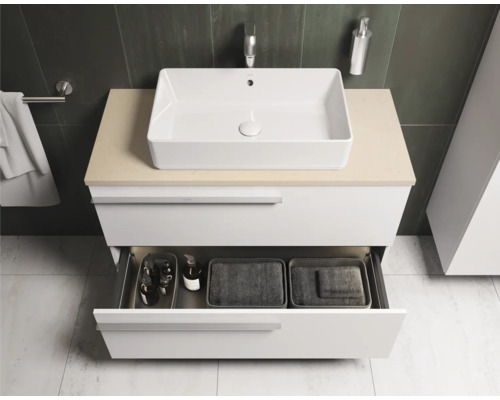 Salle de bains avec lavabo, meuble sous-vasque et tiroir ouvert pour ranger les accessoires de salle de bains.