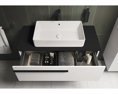 Meuble-lavabo avec vasque à poser blanche et tiroir ouvert pour accessoires de salle de bain