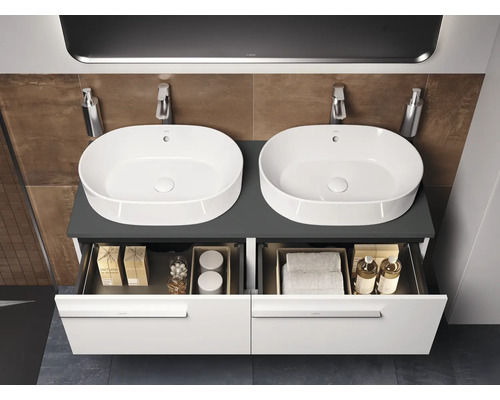 Salle de bains avec double vasque, meuble sous-vasque et tiroirs ouverts pour ranger les accessoires de salle de bains.